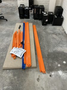 metal and wooden parts of an unbuilt shelving unit on the floor